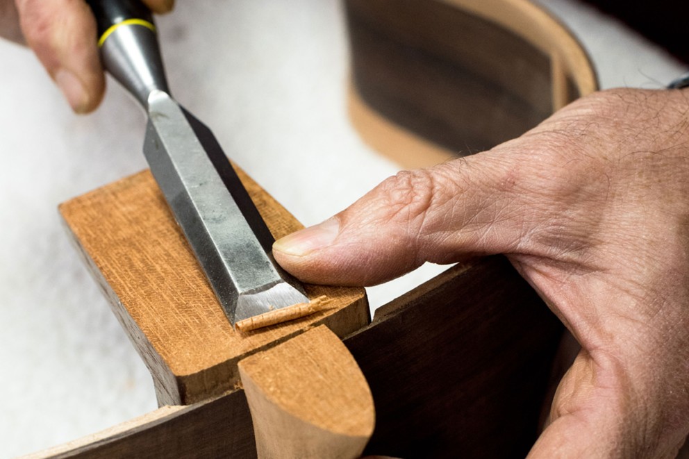 
				Millimeterarbeit: Mit dem Stechbeitel legt José Rodríguez Peña letzte Hand an den Halsfuß. Anschließend wird der Gitarrenboden aufgesetzt

			