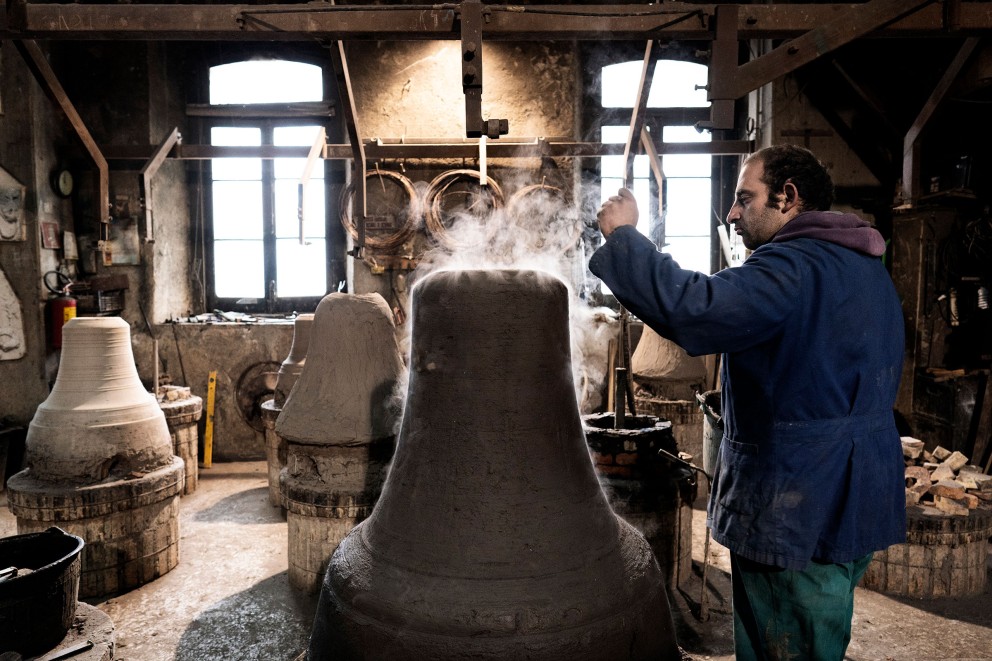 
			Prüfender Blick von Pasquale der Glockengießerei Marinelli: Mit diesem Tonmodel wird später eine Glocke gegossen. Im Inneren der Tonmodeln verströmt Kohle Wärme zum Trocknen und Rauch

		