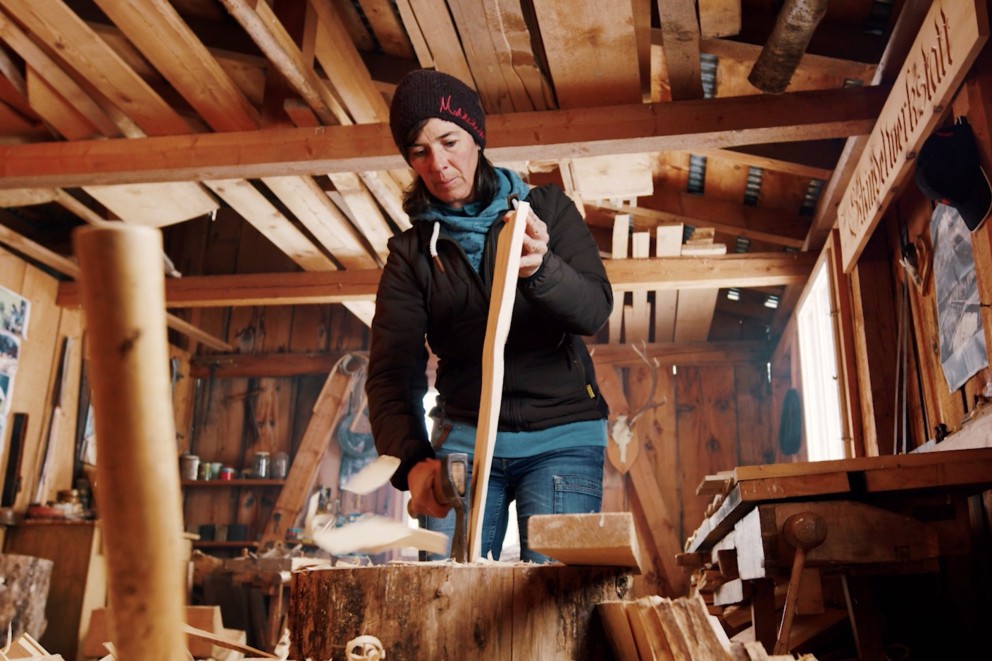 
			Eva Gredig bearbeitet einen Holzschindel mit dem Schnitzerbeil

		