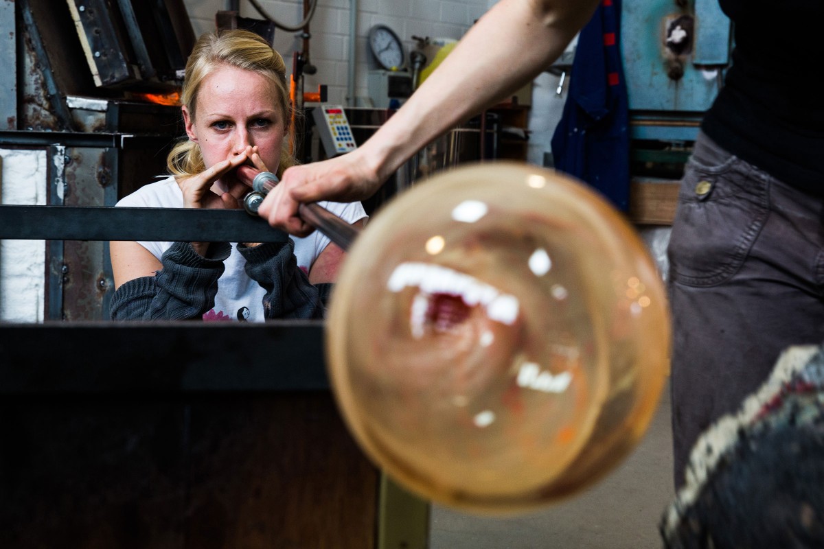 Birte Schmidt fertigt ihr erstes Glasobjekt an, indem sie es bläst. Das heißt, sie setzt ihre Lippen an die Pfeife, ein langes Stahlrohr, und pustet kräftig 