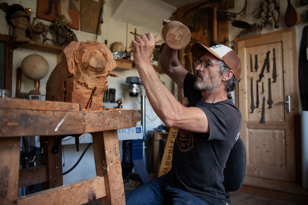 Sebastian Buchwieser in seiner Werkstatt bei der Arbeit an einer Holzskulptur. 