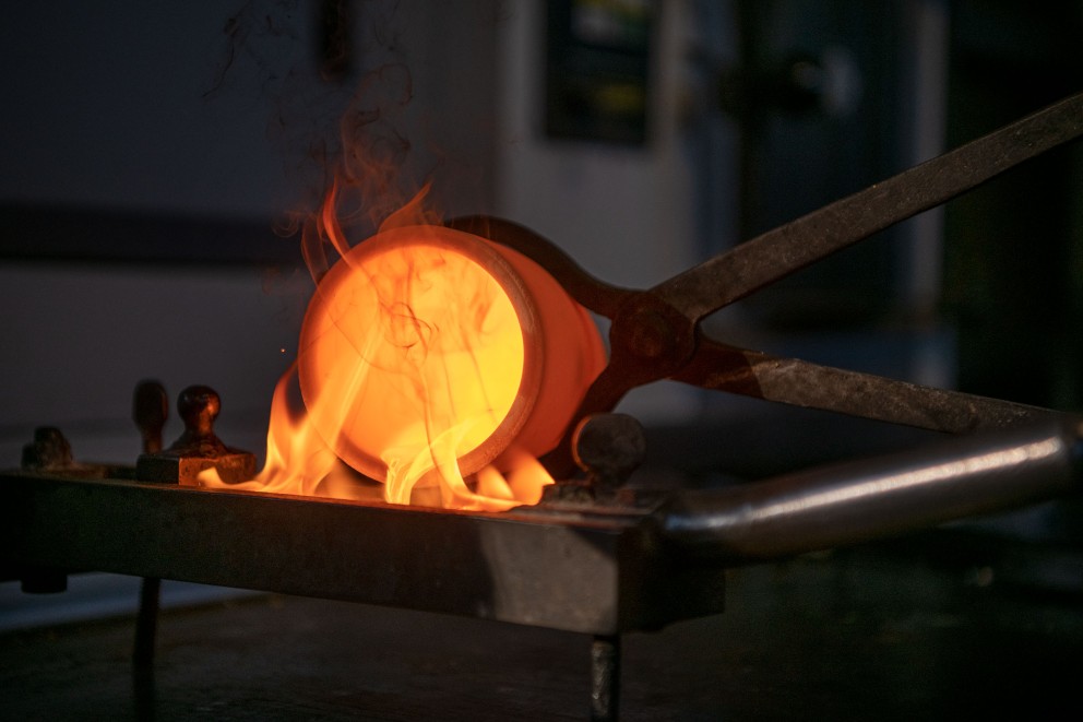 
			In der Firma Noris Blattgold gibt Dieter Dortleff Goldgranulat in einen Tiegel und erhitzt diesen in einem Ofen auf 1250 Grad. Bei dieser Temperatur schmilzt das Edelmetall. Dann füllt er es in eine Barrenform, in der das Gold abkühlt.

		