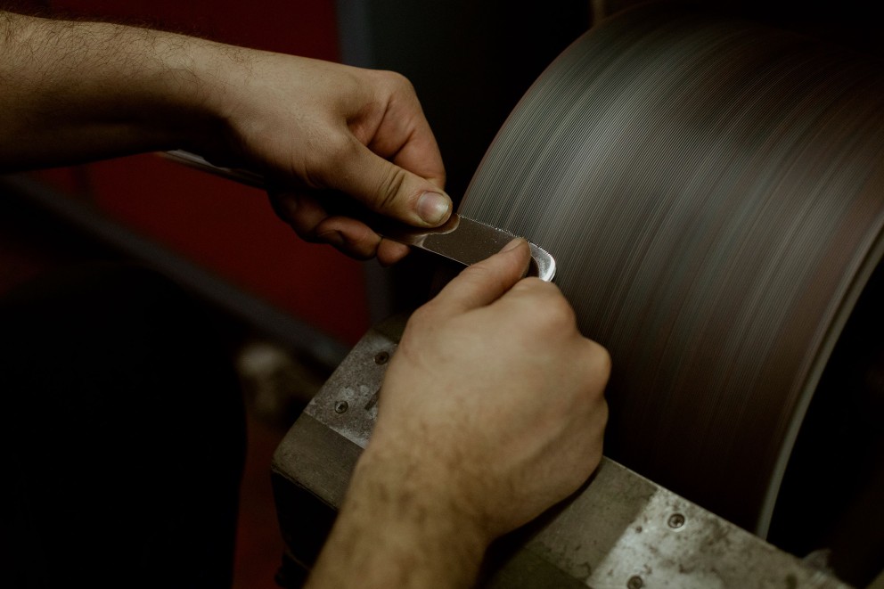 
			Zuletzt schleift Fabian mithilfe einer speziellen Schleifscheibe die Klinge scharf. Er arbeitet als Messerschmied in der Altonaer Silber Werkstatt in Hamburg.

		