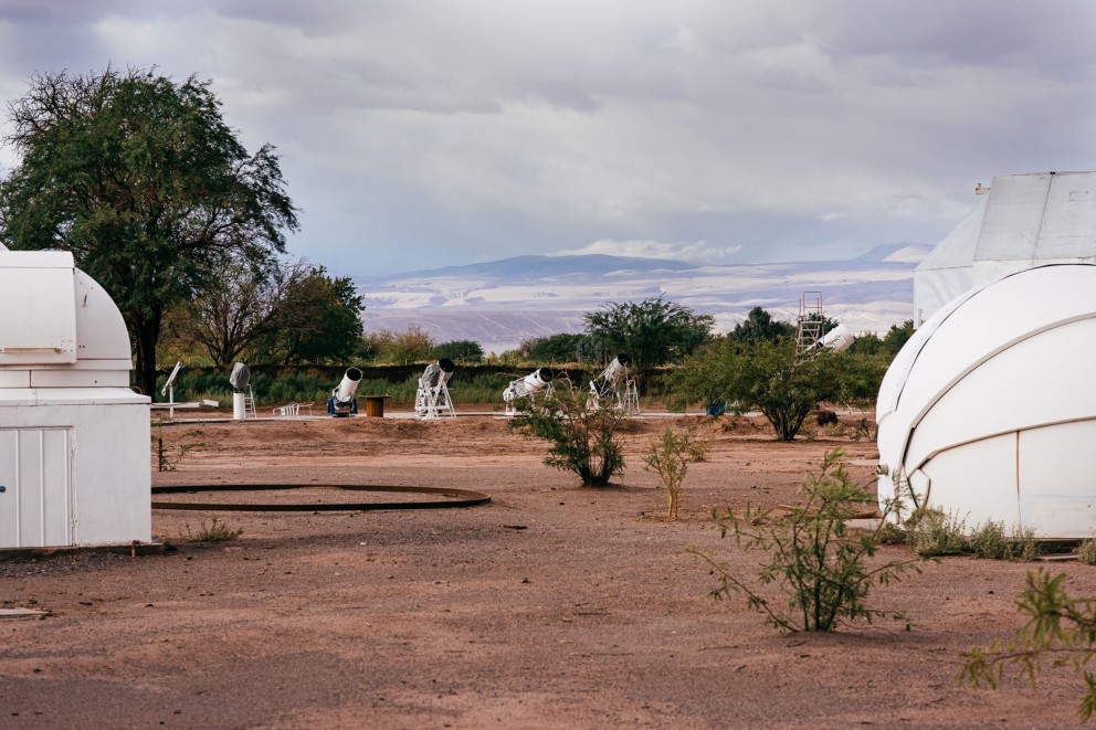 
			Mitten in der Atacama Wüste, vor dem Anden Panorama, stehen die Wetterkuppeln mit Roboter Teleskopen, die Alain Maury für Kunden aus aller Welt beaufsichtigt, dahinter die größtenteils selbst gebauten Besucherteleskope

		
