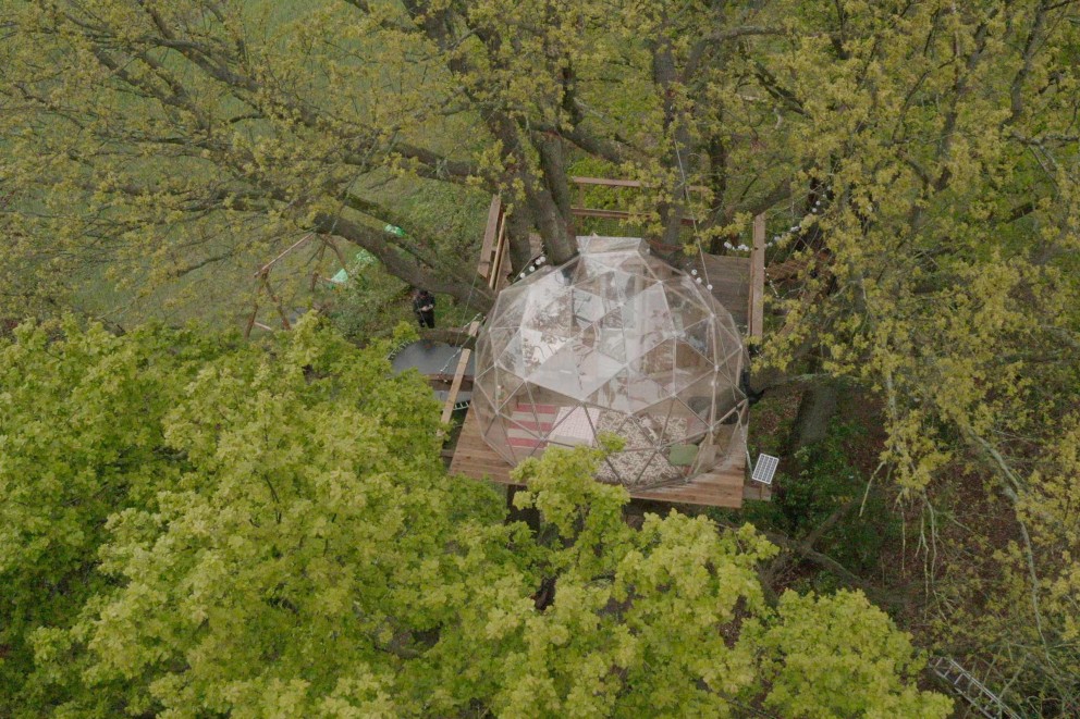 
			Das Baumhaus mit der Kuppel aus der Vogelperspektive.

		