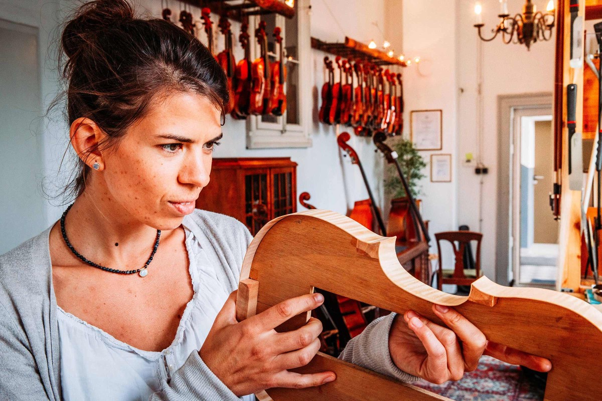 Antonia Meyer begutachtet eine selbstgebaute Geige in ihrer Werkstatt. 